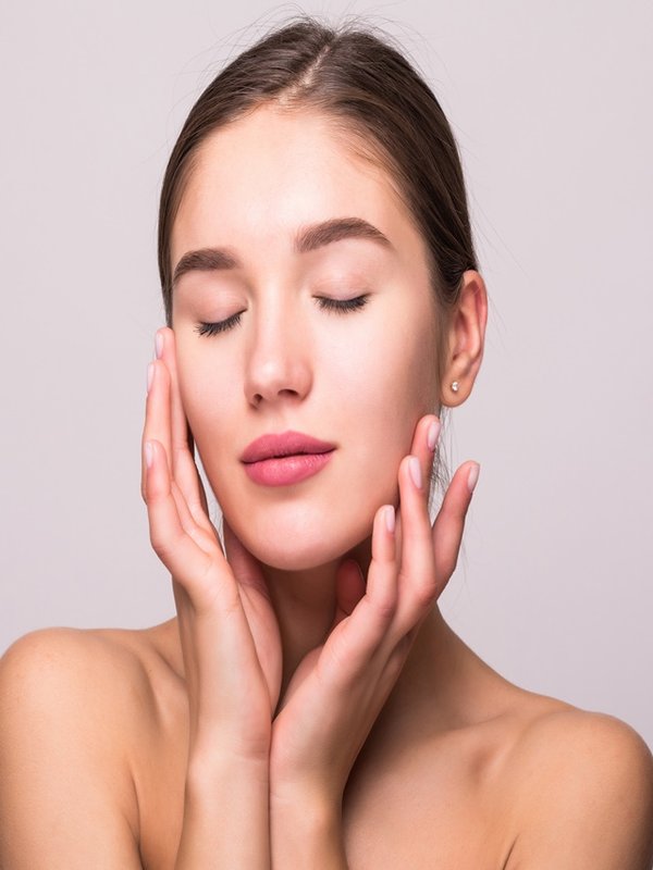 Pretty face of beautiful smiling woman posing at studio isolated on white background