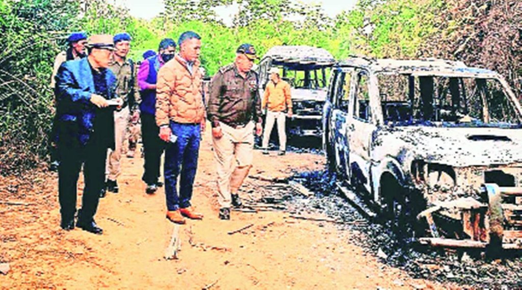 नगालैंड में जारी हिंसा में जलाई गईं गाड़ियों को देखते अधिकारी। 