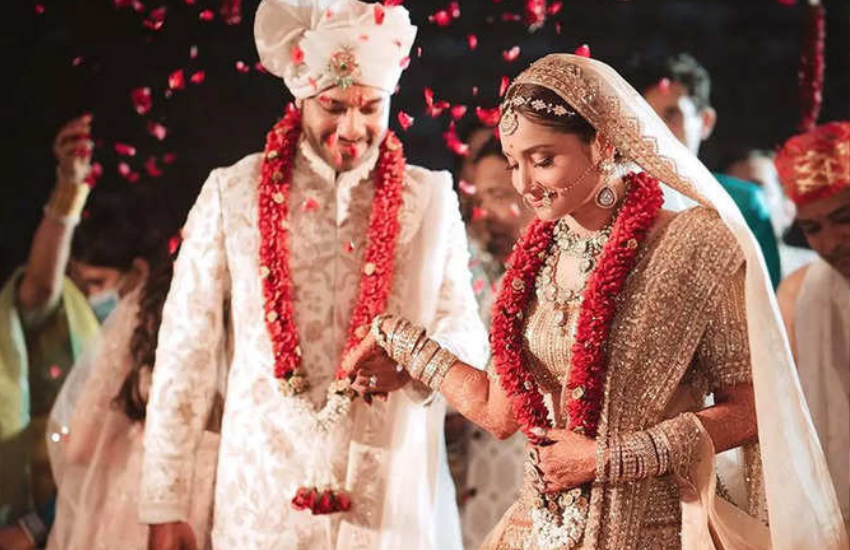 विक्की जैन ने व्हाइट सूट पहना था तो अंकिता लाइट गोल्डन लहंगे में नजर आई थीं। अंकिता ने अपने लुक को शाही टच देने के लिए जड़ाऊ ज्वैलरी पहनी थी, जिसमें माथापट्टी, नथ और भारी नेकपीस शामिल हैं। उन्होंने कलीरे और चूड़ा भी गोल्डन कलर का पहना। Photos: Social Media