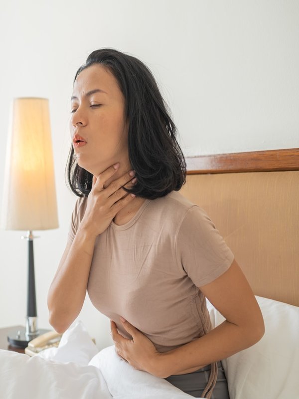 sick woman with cough and throat infection at home self isolatin