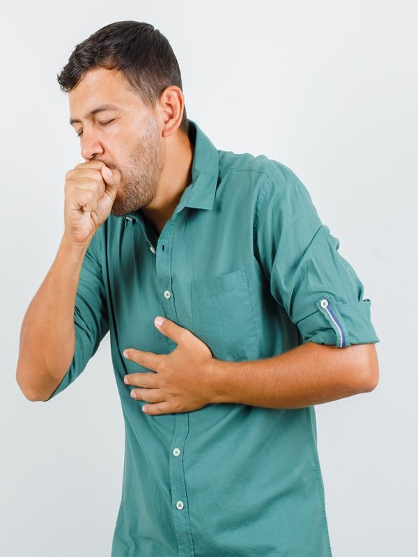 Young man suffering from cough in shirt and looking ill. front view.