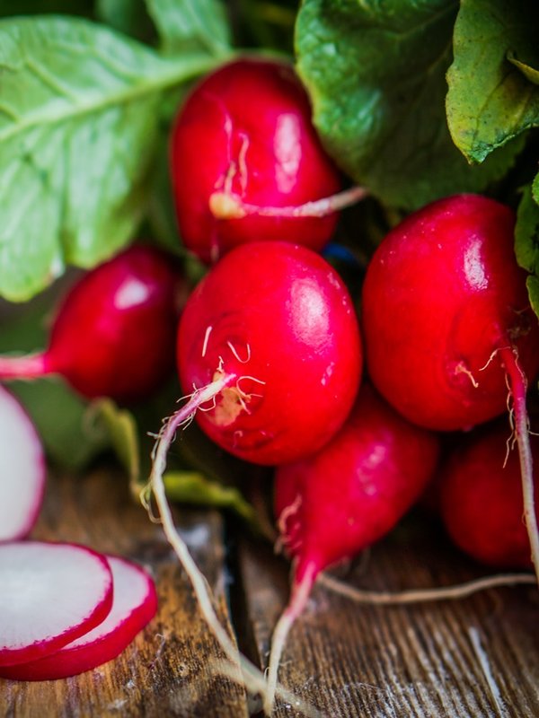 Radishes on rustic wooden background