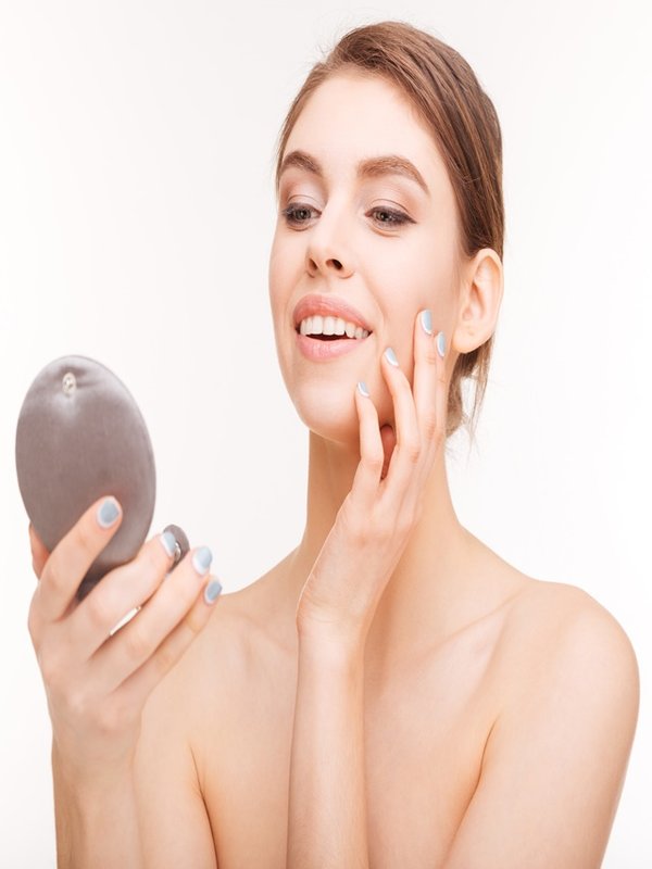 Smiling woman holding mirror