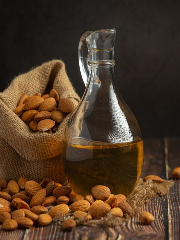 Almond oil in bottle on dark wood background