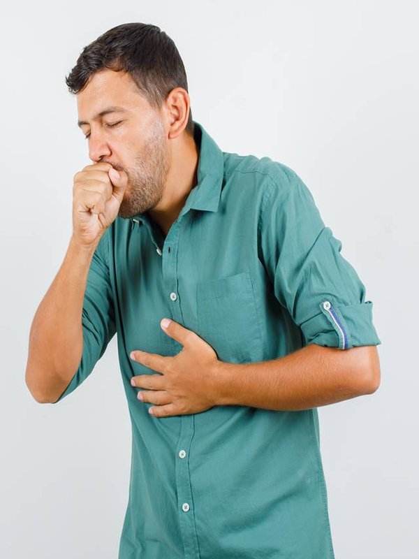 Young man suffering from cough in shirt and looking ill. front view.