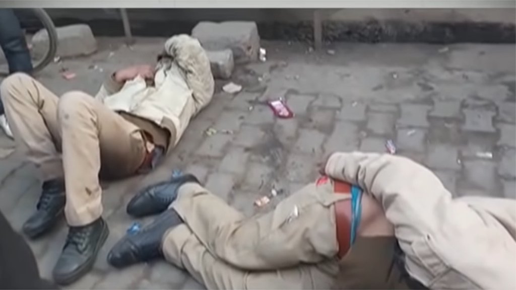 उत्तरप्रदेश के शाहजहांपुर का एक वीडियो वायरल हो रहा है जिसमें दो पुलिसकर्मी नशे में धुत होकर सड़क पर लेटे हुए दिखाई दे रहे हैं। (फोटो: स्क्रीनशॉट...वायरल वीडियो)