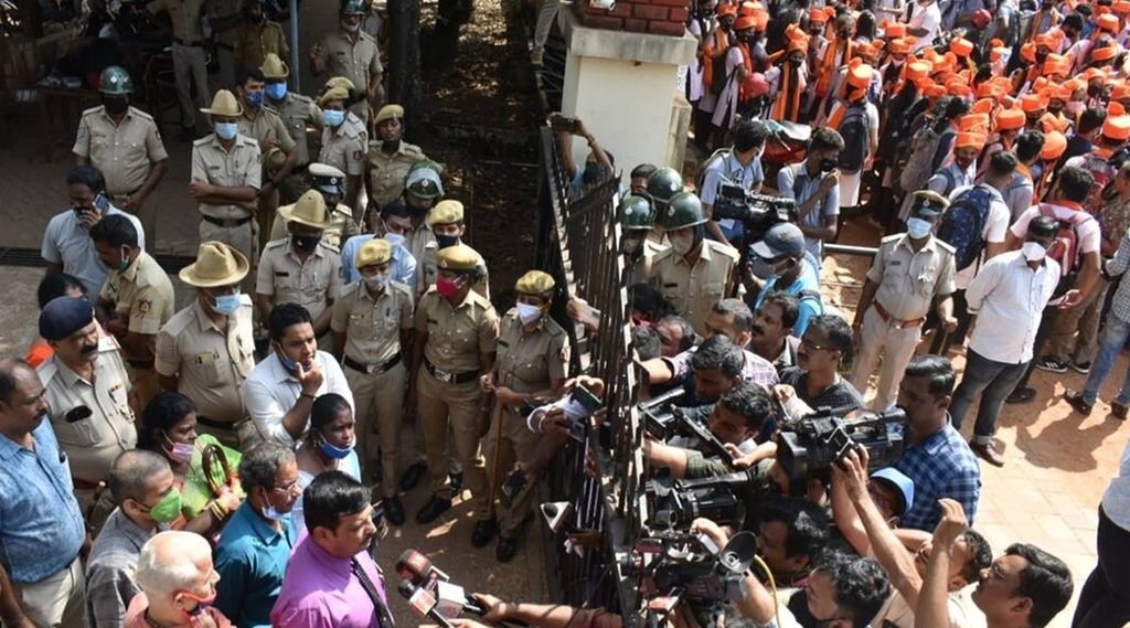 उडूपी के एमजीएम कॉलेज के बाहर कुछ स्टूडेंट्स हिजाब में और कुछ भगवा स्कॉर्फ लपेटे हुए. (Photo- Indian Express)