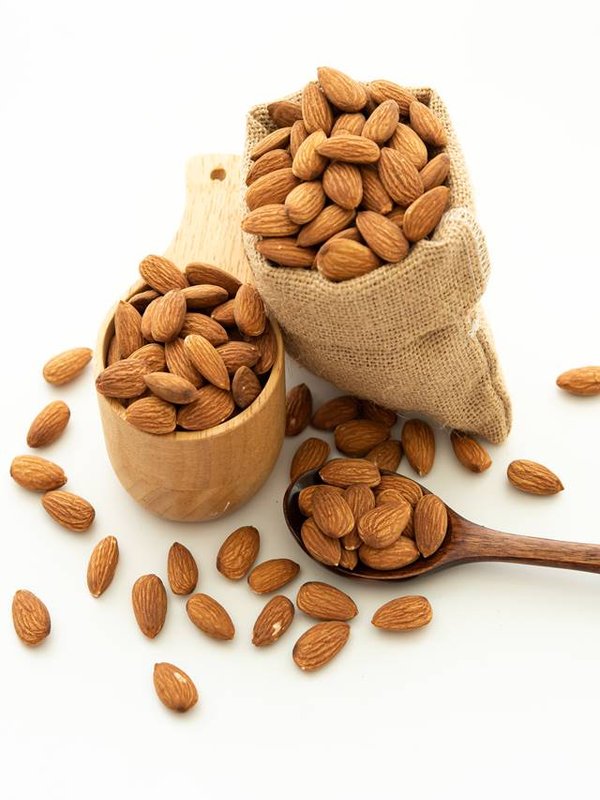 almond in a wooden spoon and bowl. Sack with almond on white bac