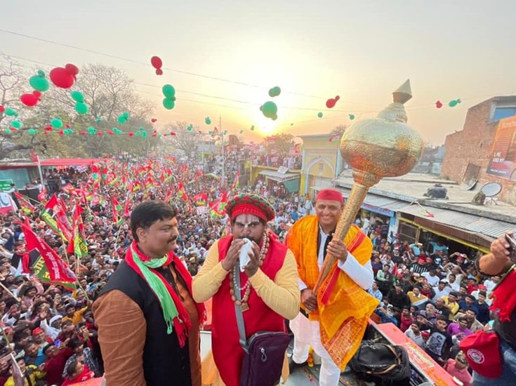 अयोध्या में रोड शो के दौरान गदा थामे अखिलेश यादव। साथ में शंख बजाते स्थानीय साधु।