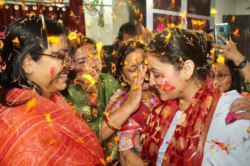 तस्वीरों में अपर्णा तमाम महिलाओं के साथ फूलों की होली खेल रही हैं।