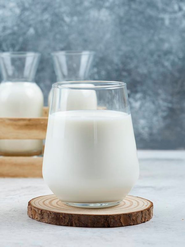 A glasses of milk on a gray background