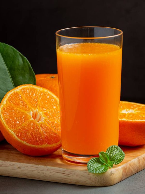 Fresh orange juice in the glass on dark background