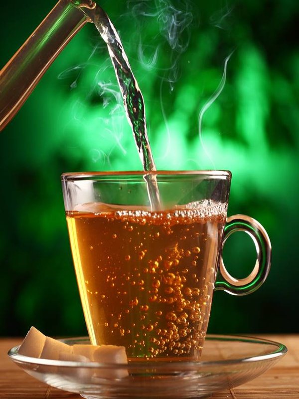 Hot green tea in glass teapot and cup