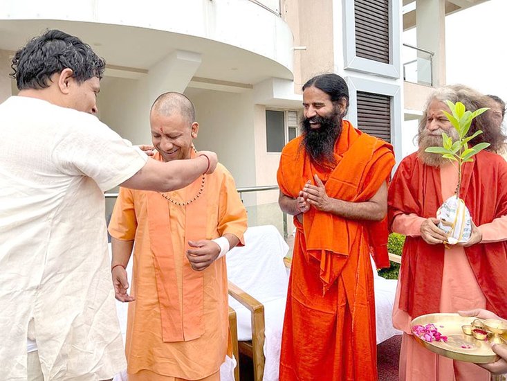 आचार्य बालकृष्ण ने योगी आदित्यनाथ को रुद्राक्ष की माला पहनाई।