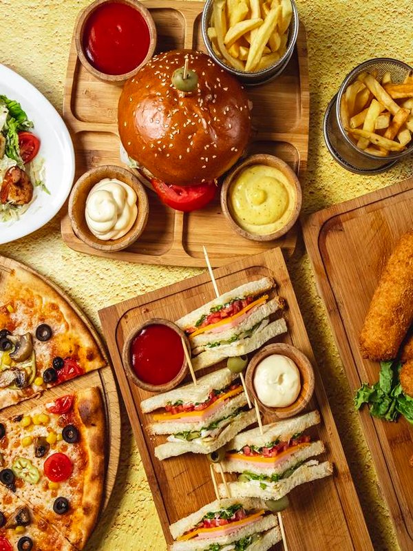 top view fast food mix mozzarella sticks club sandwich hamburger mushroom pizza caesar shrimp salad french fries ketchup mayo and cheese sauces on the table