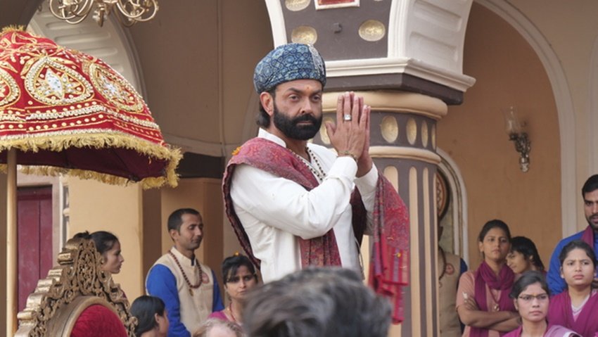 Ashram 3 Set: बॉबी देओल (Bobby Deol), त्रिधा चौधरी (Tridha Chaudhary) और ईशा गुप्ता (Esha Gupta) अभिनीत आश्रम 3 (Ashram 3) ओटीटी (OTT) प्लेटफॉर्म एमएक्स प्लेयर (MX Player) पर रिलीज हो चुकी है। इस सीरीज (Web Series) के तीसरे सीजन को भी दर्शकों का भरपूर प्यार मिल रहा है। सीरीज में बॉबी देओल बाबा निराला के आश्रम का सेट काफी भव्य नजर आया है। आइए जानते हैं किस पैलेस में बना था यह आश्रम:
