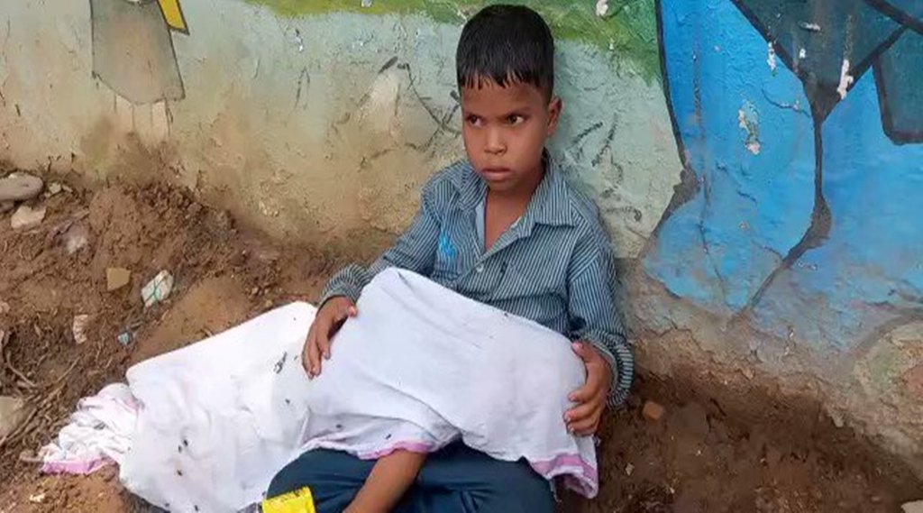 मुरैना के एक अस्‍पताल परिसर में छोटे भाई का शव लेकर वाहन की प्रतीक्षा करता बालक। 