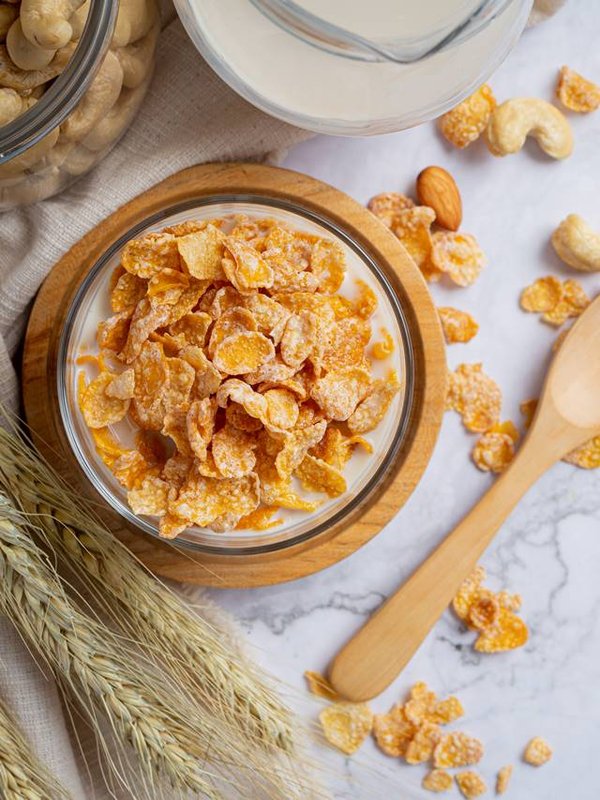 Cereal in bowl and milk on marble background