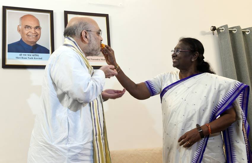 अमित शाह को मिठाई खिलातीं द्रौपदी मुर्मू।