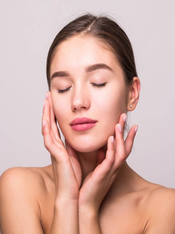 Pretty face of beautiful smiling woman posing at studio isolated on white background