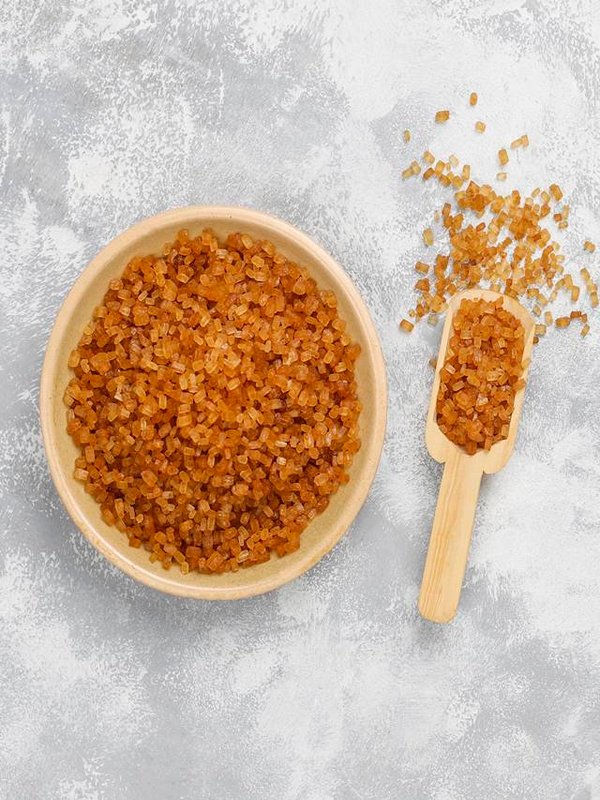 Brown sugar in ceramic plate on concrete background,top view