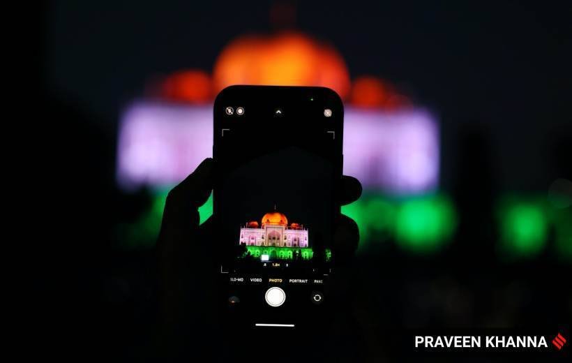 अपने मोबाइल में जगमगाते मकबरे को कैद करता एक शख्स।