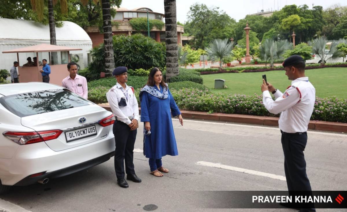 संसद परिसर में बीजेपी सांसद मेनका गांधी के साथ फोटो खिंचवाता ट्रैफिक पुलिसकर्मी।