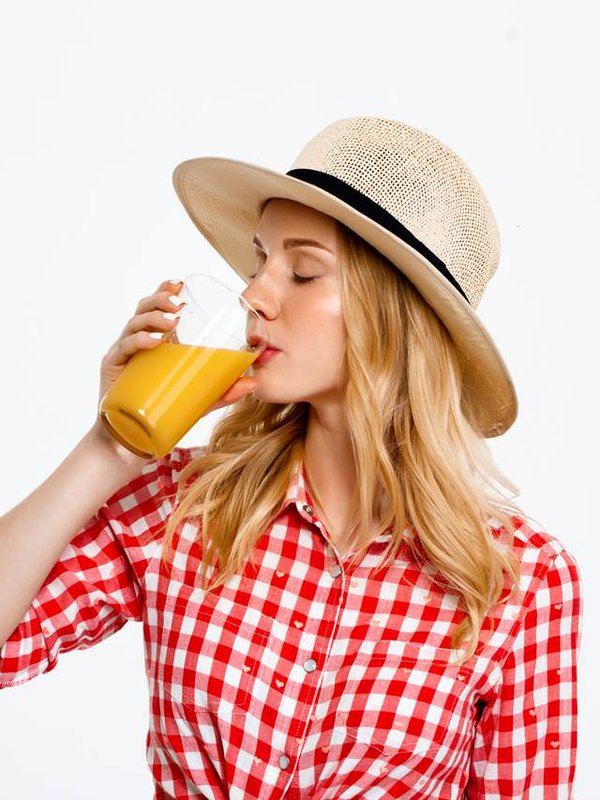 Portrait of beautiful country girl with juice over white background.