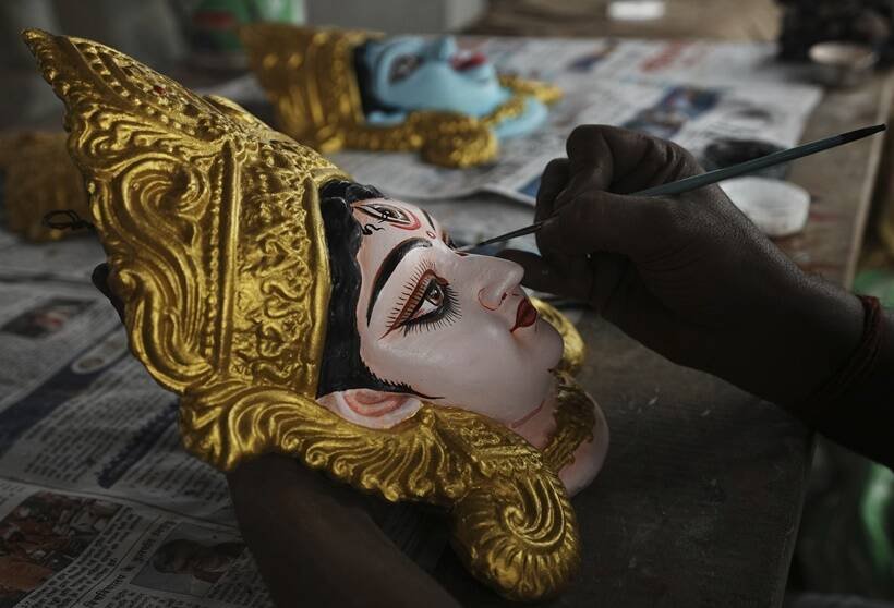 हैदराबाद में मां दुर्गा की प्रतिमा में रंग भरता एक कलाकार। (Sept. 20. AP)