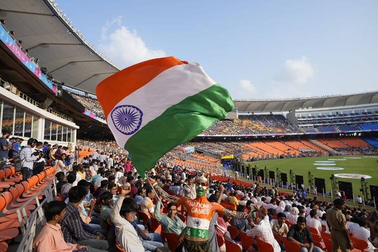 उद्घाटन समारोह के दौरान एक व्यक्ति तिरंगा राष्ट्रीय ध्वज लहराता हुआ।(AP Photo/Ajit Solanki)