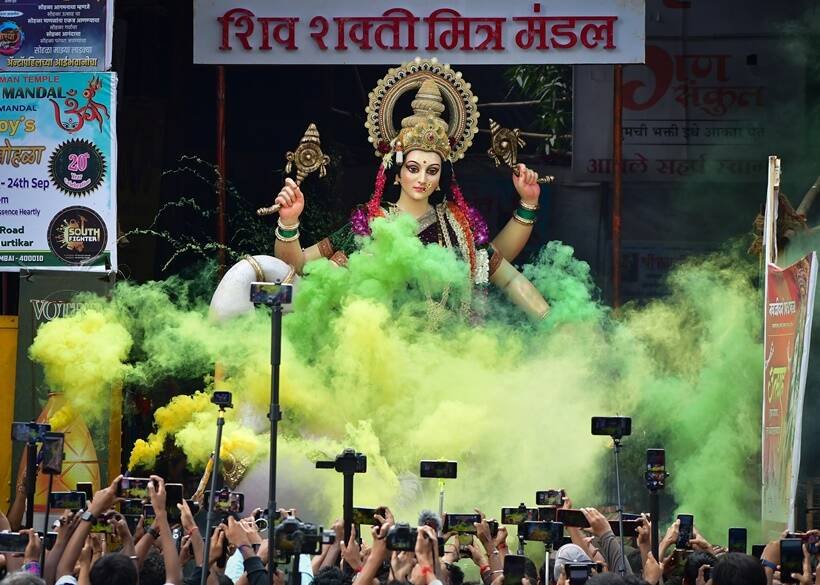 मुंबई के लालबाग में स्थापना के लिए देवी दुर्गा की प्रतिमा ले जाते श्रद्धालु। (Sept. 24, 2022. PTI)
