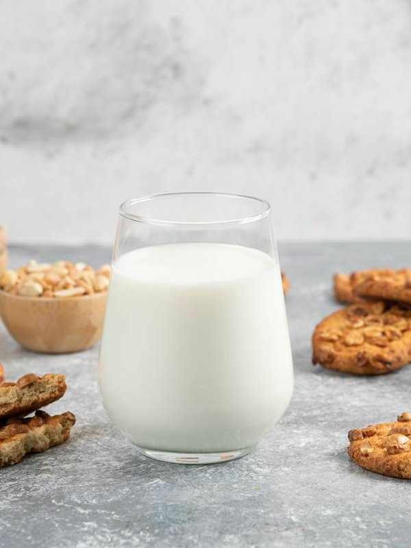 Glass of milk and homemade cookies with honey on marble background