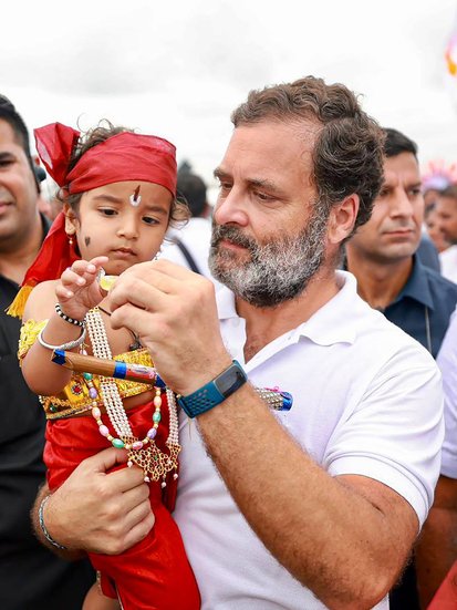 बच्चे को गोद में लिये राहुल गांधी।