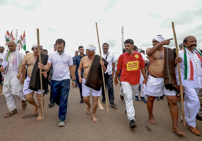 कर्नाटक के लोकल लोगों के साथ लाठी लेकर चलते राहुल।