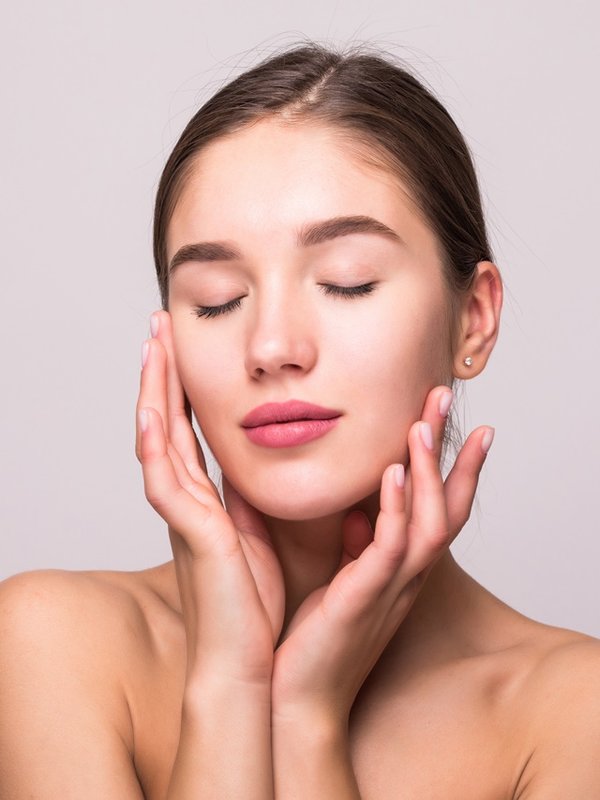 Pretty face of beautiful smiling woman posing at studio isolated on white background