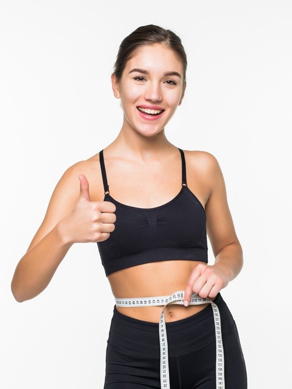 Young fitness woman measure with tape her belly isolated on white background