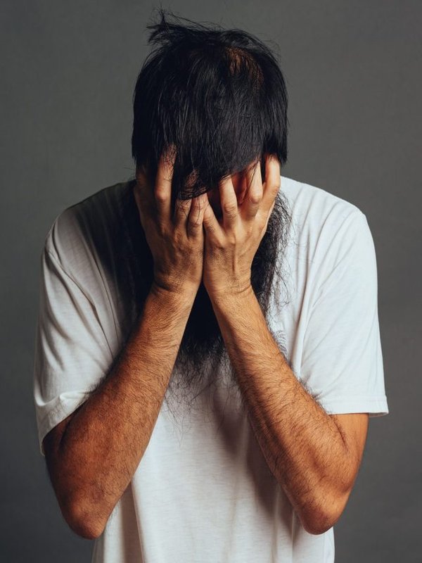man stress out and cover his face by his hands