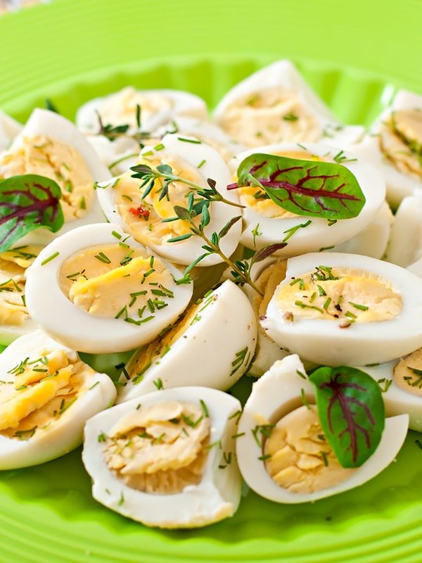 Boiled quail eggs halves on a green plate