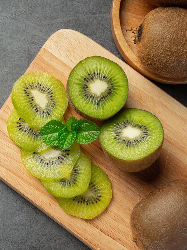 Fresh kiwi, cut into half, put on wooden cutting board