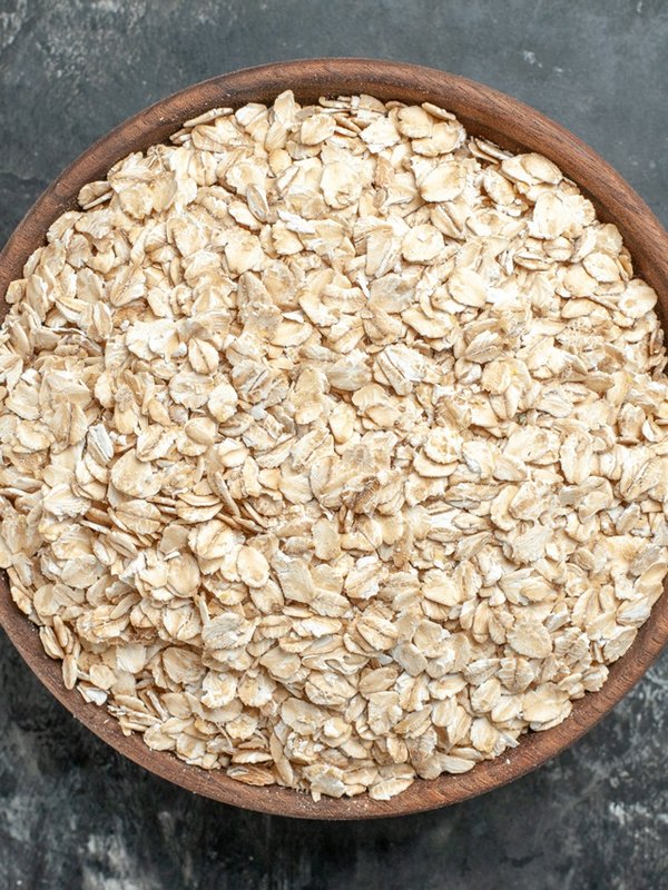 top-view-organic-oat-bran-brown-wooden-pot-dark-background