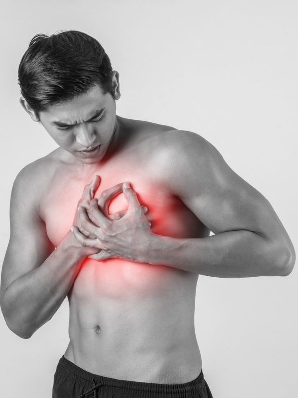 Young man has heart attack isolated on white background.