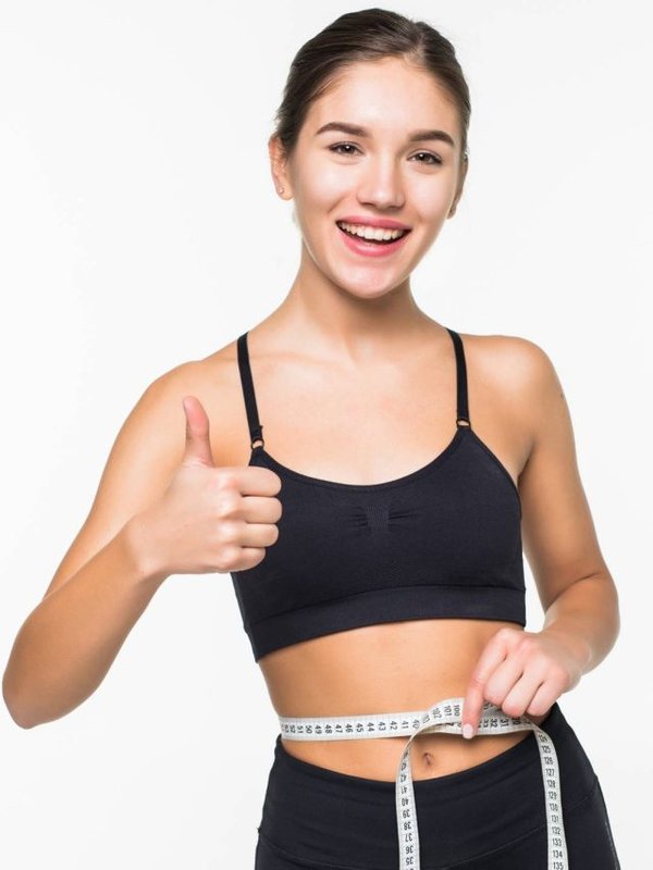 Young fitness woman measure with tape her belly isolated on white background