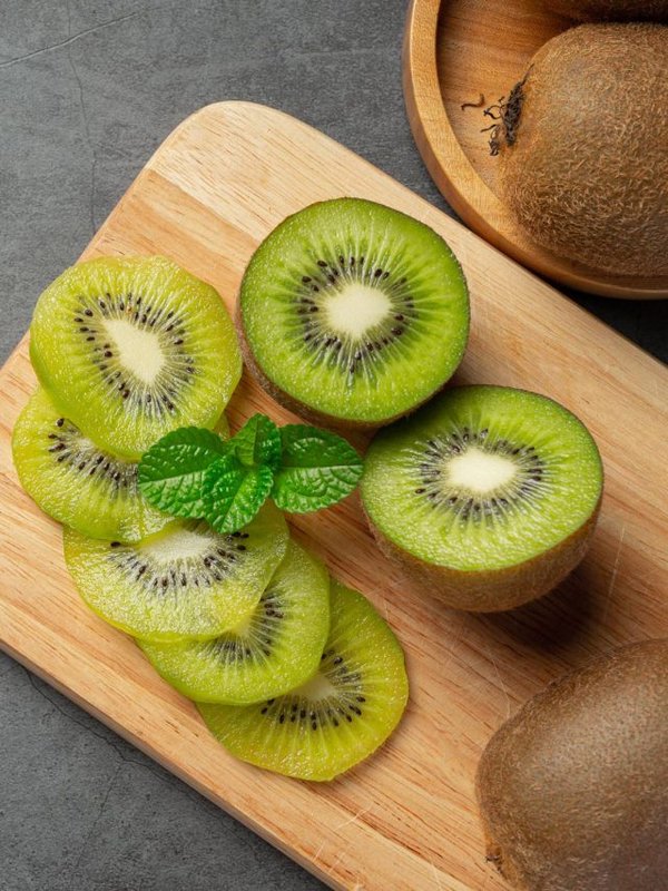 Fresh kiwi, cut into half, put on wooden cutting board