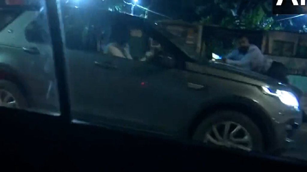person hanging on car bonnet