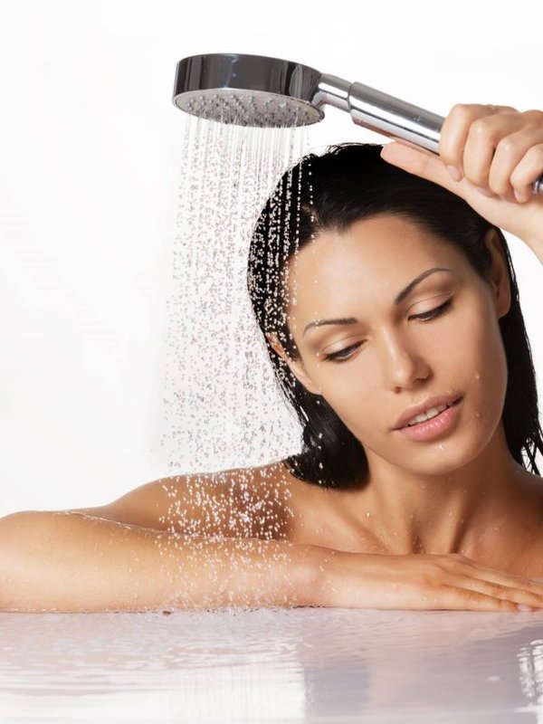 beautiful brunette woman holds shower in hands