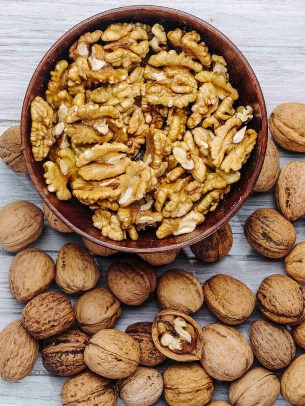 top view of walnuts in a bowl on rustic background