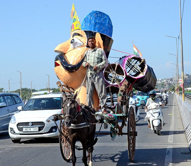 A horse-cart driver transports an effigy of Ravana ahead of the Dussehra festival