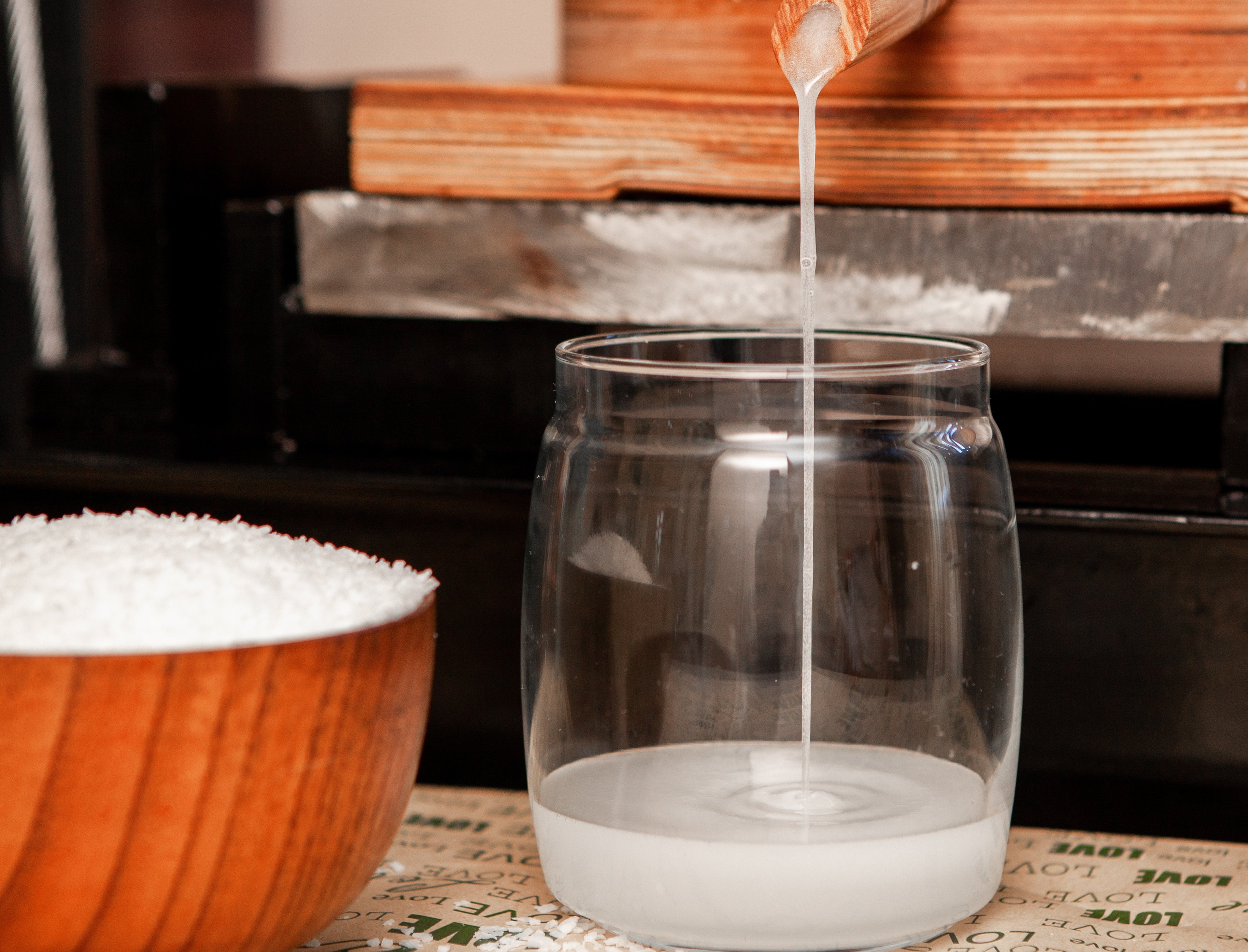Filtering coconut juice into a glass jar side view