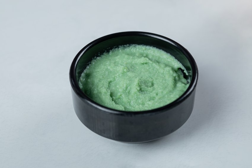 Green wasabi sauce in a black saucer