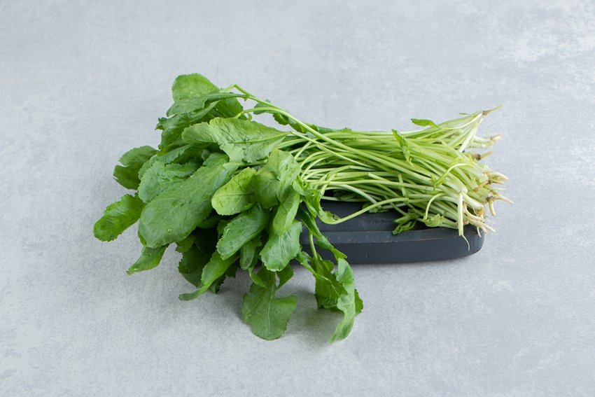 A tray of fresh watercress , on the marble background